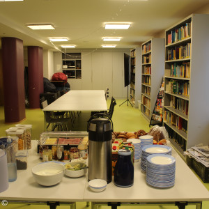 Speisesaal mit Frühstücksbuffet im Vordergrund und Tischen im Hintergrund.
